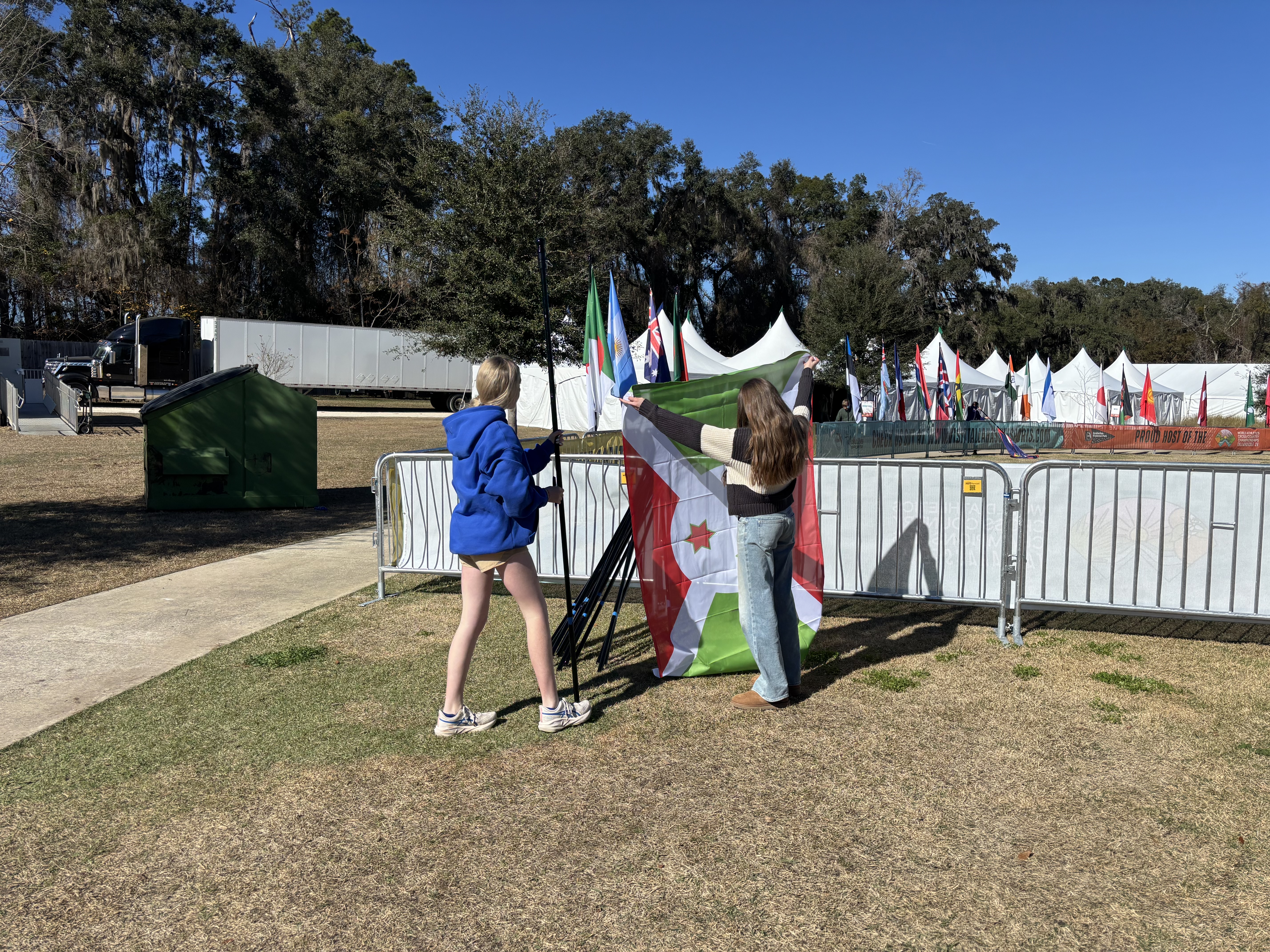 Athletes and community members engaged in a collaborative volunteer service activity together, demonstrating compassion and teamwork in an outdoor community setting, with visible expressions of purpose, joy, and shared commitment to making a positive impact